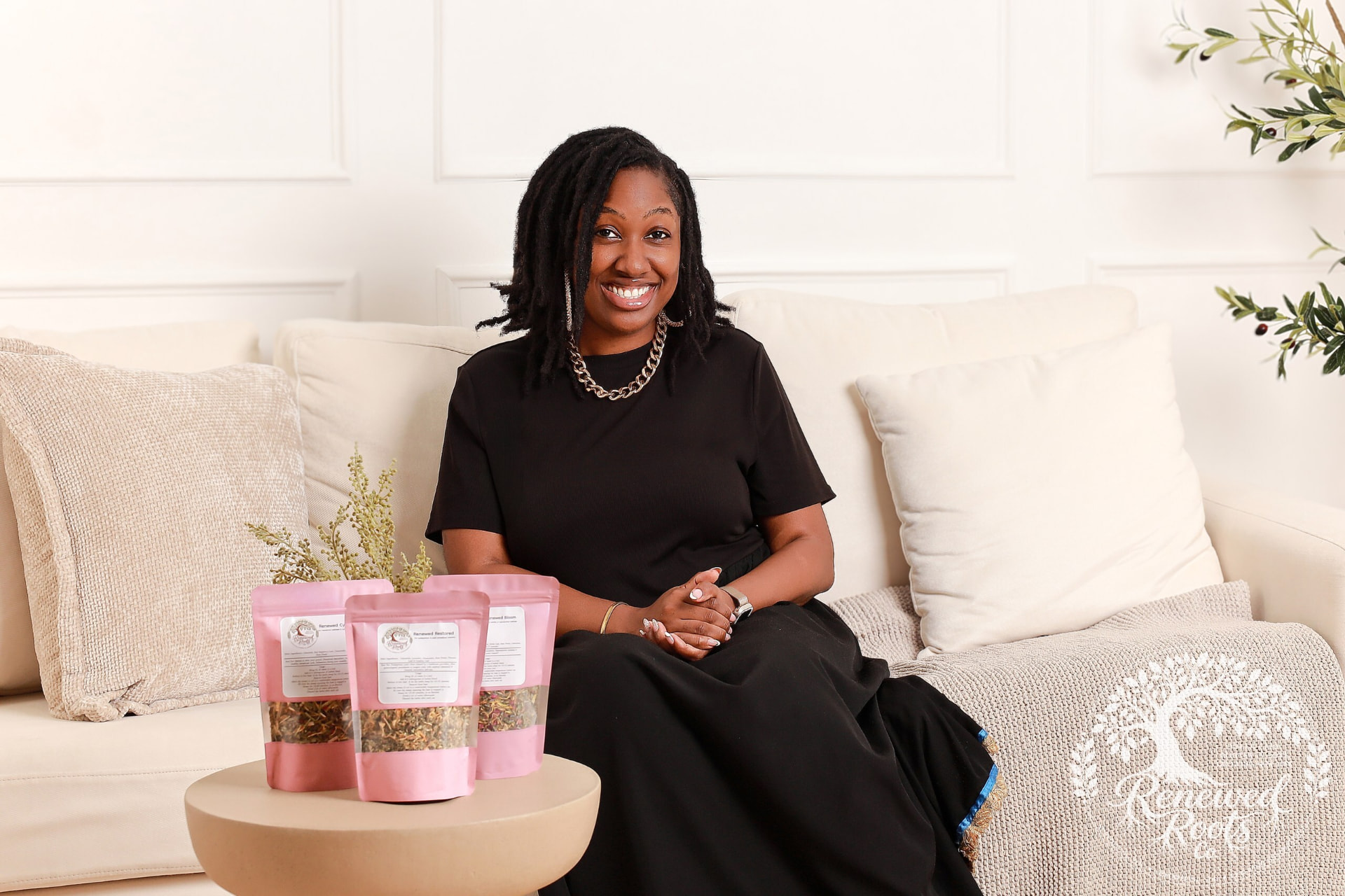 Eliana seated with Renewed Roots care products
